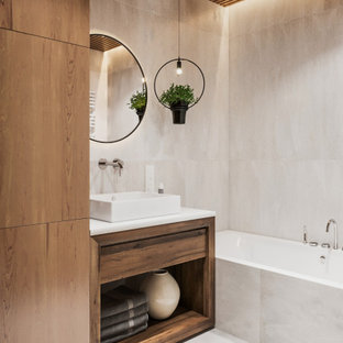 Mid-sized contemporary master bathroom in Other with flat-panel cabinets, medium wood cabinets, beige tile, porcelain tile, white walls, porcelain floors, solid surface benchtops, white floor, white benchtops, an alcove tub, a vessel sink and wood walls.