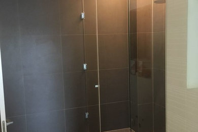 На фото: ванная комната в современном стиле с угловым душем, стеклянной столешницей и душем с распашными дверями