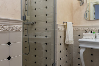 На фото: ванная комната в стиле неоклассика (современная классика) с душевой кабиной, душем над ванной, серой плиткой, бежевыми стенами, консольной раковиной и коричневым полом с