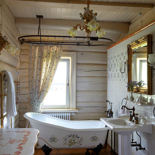 Mid-sized shabby-chic style bathroom in Other with a claw-foot tub, medium hardwood floors, a pedestal sink, white walls and a shower curtain.
