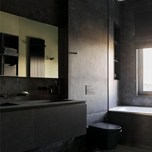 Foto di una grande stanza da bagno con doccia contemporanea con ante lisce, ante nere, vasca da incasso, doccia alcova, orinatoio, piastrelle nere, piastrelle in gres porcellanato, pareti nere, pavimento in gres porcellanato, lavabo sottopiano, pavimento nero e top nero