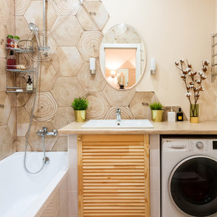Inspiration för ett litet minimalistiskt beige beige en-suite badrum, med luckor med lamellpanel, en dusch/badkar-kombination, keramikplattor, beige väggar, klinkergolv i keramik, laminatbänkskiva, skåp i ljust trä, ett platsbyggt badkar, beige kakel, ett nedsänkt handfat och beiget golv