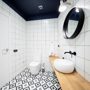Diseño de cuarto de baño con ducha, escandinavo, con sanitario de dos piezas, baldosas y/o azulejos blancos, lavabo sobreencimera, encimera de madera, suelo multicolor y encimeras beige