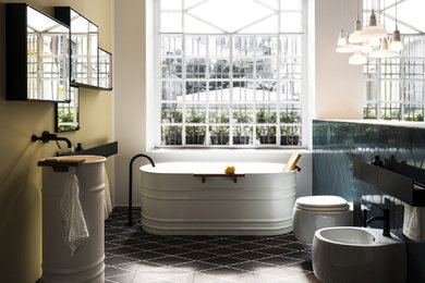На фото: главная ванная комната в современном стиле с отдельно стоящей ванной, раздельным унитазом, монолитной раковиной и тумбой под одну раковину с