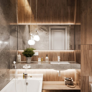 Foto de cuarto de baño con ducha, contemporáneo, de tamaño medio, con bañera encastrada sin remate, ducha empotrada, sanitario de pared, baldosas y/o azulejos grises, baldosas y/o azulejos de porcelana, paredes grises, suelo de baldosas de porcelana, lavabo bajoencimera, encimera de azulejos, suelo gris y encimeras grises