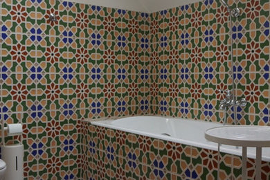 Идея дизайна: главная ванная комната среднего размера в средиземноморском стиле с фасадами с утопленной филенкой, темными деревянными фасадами, полновстраиваемой ванной, инсталляцией, разноцветной плиткой, керамогранитной плиткой, разноцветными стенами, полом из керамической плитки, накладной раковиной и разноцветным полом