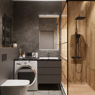 Mittelgroßes Modernes Duschbad mit flächenbündigen Schrankfronten, grauen Schränken, Duschnische, Wandtoilette, grauen Fliesen, Porzellanfliesen, grauer Wandfarbe, Porzellan-Bodenfliesen, Unterbauwaschbecken, Mineralwerkstoff-Waschtisch, grauem Boden, Duschvorhang-Duschabtrennung, schwarzer Waschtischplatte, Wäscheaufbewahrung, Einzelwaschbecken und schwebendem Waschtisch in Sonstige