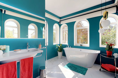 Ejemplo de cuarto de baño principal mediterráneo de tamaño medio con bañera exenta, sanitario de pared, paredes verdes, suelo de baldosas de porcelana, lavabo suspendido y suelo blanco