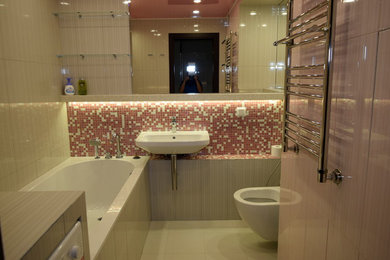 モスクワにある高級な広いトランジショナルスタイルのおしゃれなマスターバスルーム (アンダーマウント型浴槽、壁掛け式トイレ、ピンクのタイル、セラミックタイル、ピンクの壁、セラミックタイルの床、壁付け型シンク、大理石の洗面台、ベージュの床、オープンシャワー、ベージュのカウンター) の写真