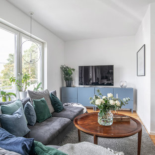 Inspiration för små nordiska vardagsrum, med vita väggar, mellanmörkt trägolv, en fristående TV och brunt golv