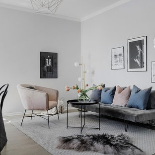 Idéer för att renovera ett litet minimalistiskt allrum med öppen planlösning, med ljust trägolv och grå väggar