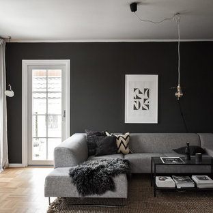 Inredning av ett minimalistiskt litet separat vardagsrum, med svarta väggar, ljust trägolv och beiget golv