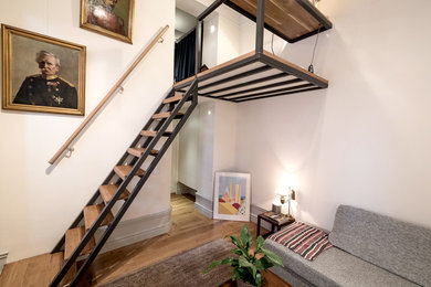 Modelo de salón tipo loft nórdico pequeño con paredes blancas y suelo de madera en tonos medios
