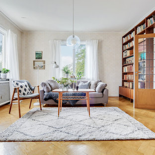 Idéer för ett skandinaviskt separat vardagsrum, med ett bibliotek, beige väggar, mellanmörkt trägolv och brunt golv