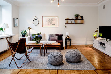 Inspiration for a large scandinavian formal open plan living room in Gothenburg with white walls, medium hardwood flooring, no fireplace and a freestanding tv.