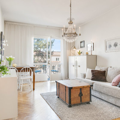 Mid-sized danish open concept and formal medium tone wood floor living room photo in Stockholm with white walls and a wall-mounted tv