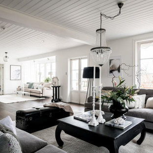 Foto på ett skandinaviskt allrum med öppen planlösning, med vita väggar, mörkt trägolv och brunt golv