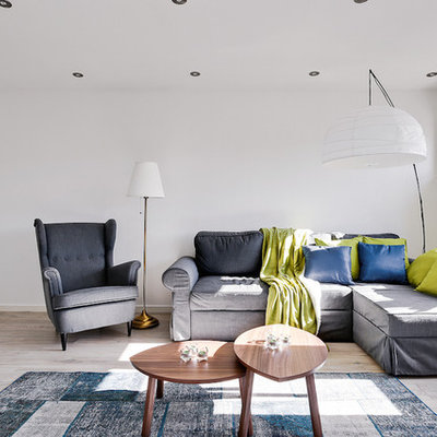 Example of a mid-sized danish open concept light wood floor living room design in Stockholm with white walls, no fireplace and no tv