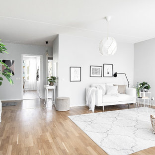 Foto på ett skandinaviskt allrum med öppen planlösning, med grå väggar, ljust trägolv och beiget golv