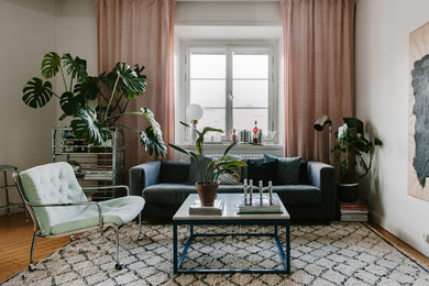 This is an example of a large scandi living room in Stockholm with white walls, medium hardwood flooring and no fireplace.