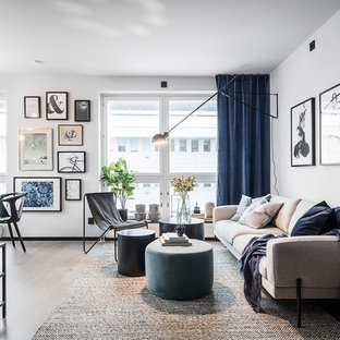 Foto på ett stort skandinaviskt allrum med öppen planlösning, med vita väggar, ljust trägolv och grått golv
