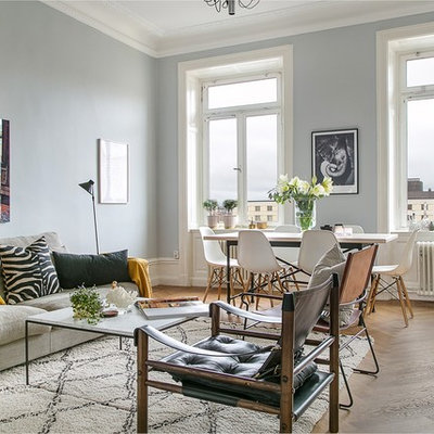 Example of a large danish formal and enclosed medium tone wood floor living room design in Stockholm with gray walls, no fireplace and no tv
