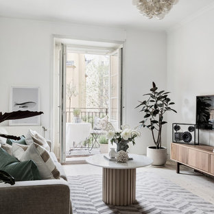 Inspiration för ett minimalistiskt vardagsrum, med vita väggar, ljust trägolv, en väggmonterad TV och beiget golv