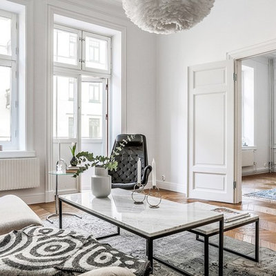 Example of a danish formal and open concept medium tone wood floor and beige floor living room design in Malmo with white walls and no tv