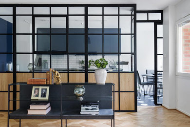 Mittelgroßes, Offenes Uriges Wohnzimmer mit weißer Wandfarbe und braunem Holzboden in Stockholm
