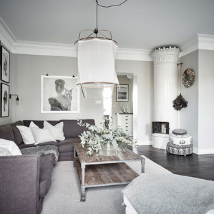 Inspiration för ett skandinaviskt separat vardagsrum, med beige väggar, mörkt trägolv, en öppen hörnspis, en spiselkrans i metall och svart golv