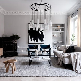 Inspiration för ett funkis vardagsrum, med grå väggar, ljust trägolv, en öppen hörnspis, en väggmonterad TV och grått golv