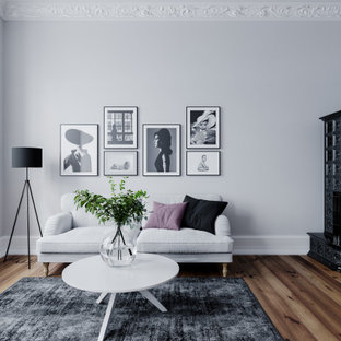 Inspiration för mellanstora moderna vardagsrum, med grå väggar, en öppen hörnspis, en spiselkrans i metall och brunt golv