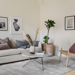 Idéer för att renovera ett minimalistiskt vardagsrum, med beige väggar, ljust trägolv och beiget golv