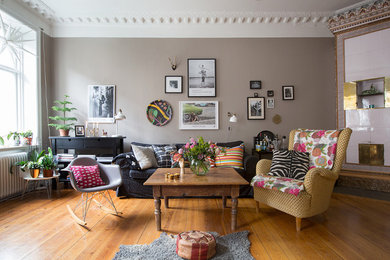 Imagen de salón para visitas abierto bohemio grande sin chimenea y televisor con paredes marrones y suelo de madera en tonos medios