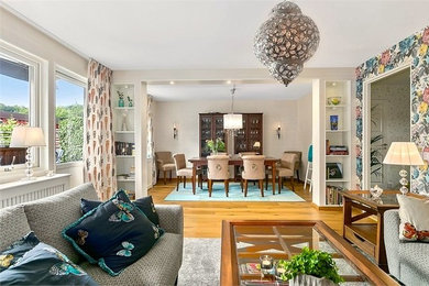Mittelgroßes, Repräsentatives, Offenes Klassisches Wohnzimmer mit bunten Wänden, braunem Holzboden und freistehendem TV in Göteborg