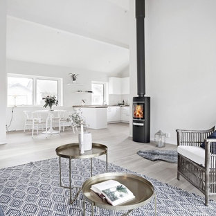 Idéer för att renovera ett minimalistiskt allrum med öppen planlösning, med ett finrum, vita väggar, ljust trägolv och en öppen vedspis