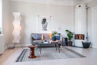 Großes, Repräsentatives, Fernseherloses, Offenes Skandinavisches Wohnzimmer mit beiger Wandfarbe, hellem Holzboden und Kaminofen in Stockholm
