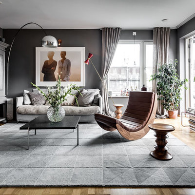Living room - large scandinavian formal and open concept medium tone wood floor living room idea in Stockholm with gray walls, a concealed tv and no fireplace