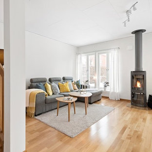 Idéer för att renovera ett funkis vardagsrum, med ett finrum, vita väggar, mellanmörkt trägolv, en öppen vedspis och brunt golv