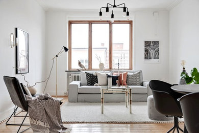 Skandinavisches Wohnzimmer mit braunem Holzboden und braunem Boden in Malmö