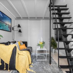 Idéer för nordiska loftrum, med ljust trägolv, beiget golv, grå väggar och en väggmonterad TV