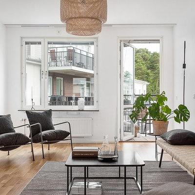 Living room - mid-sized scandinavian enclosed and formal light wood floor living room idea in Stockholm with white walls and no tv