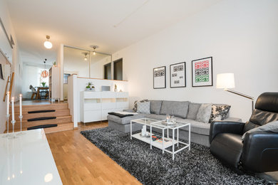 Mittelgroßes, Offenes Modernes Wohnzimmer mit weißer Wandfarbe und TV-Wand in Göteborg