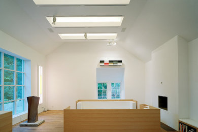 Großes, Repräsentatives, Offenes Modernes Wohnzimmer mit weißer Wandfarbe, braunem Holzboden, Gaskamin und verstecktem TV in Stockholm