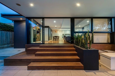 Große, Überdachte Moderne Veranda hinter dem Haus mit Outdoor-Küche und Natursteinplatten in Sydney