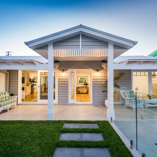 Inspiration for a mid-sized beach style front yard verandah in Gold Coast - Tweed with a pergola and tile.