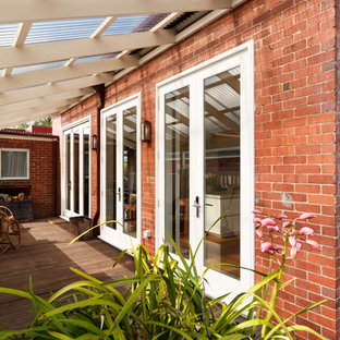 Idee per un piccolo portico chic nel cortile laterale con un portico chiuso, pedane e una pergola