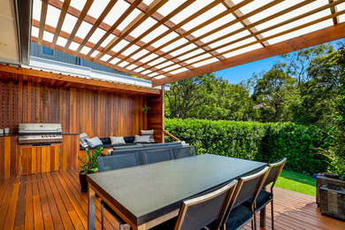 Ejemplo de terraza contemporánea de tamaño medio en patio trasero con cocina exterior y toldo