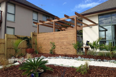 Kleines Mediterranes Veranda im Vorgarten mit Pflanzwand, Dielen und Pergola in Auckland