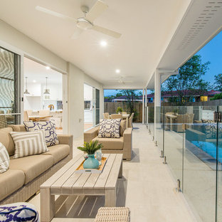 Inspiration for a mid-sized beach style backyard verandah in Brisbane with a roof extension and tile.